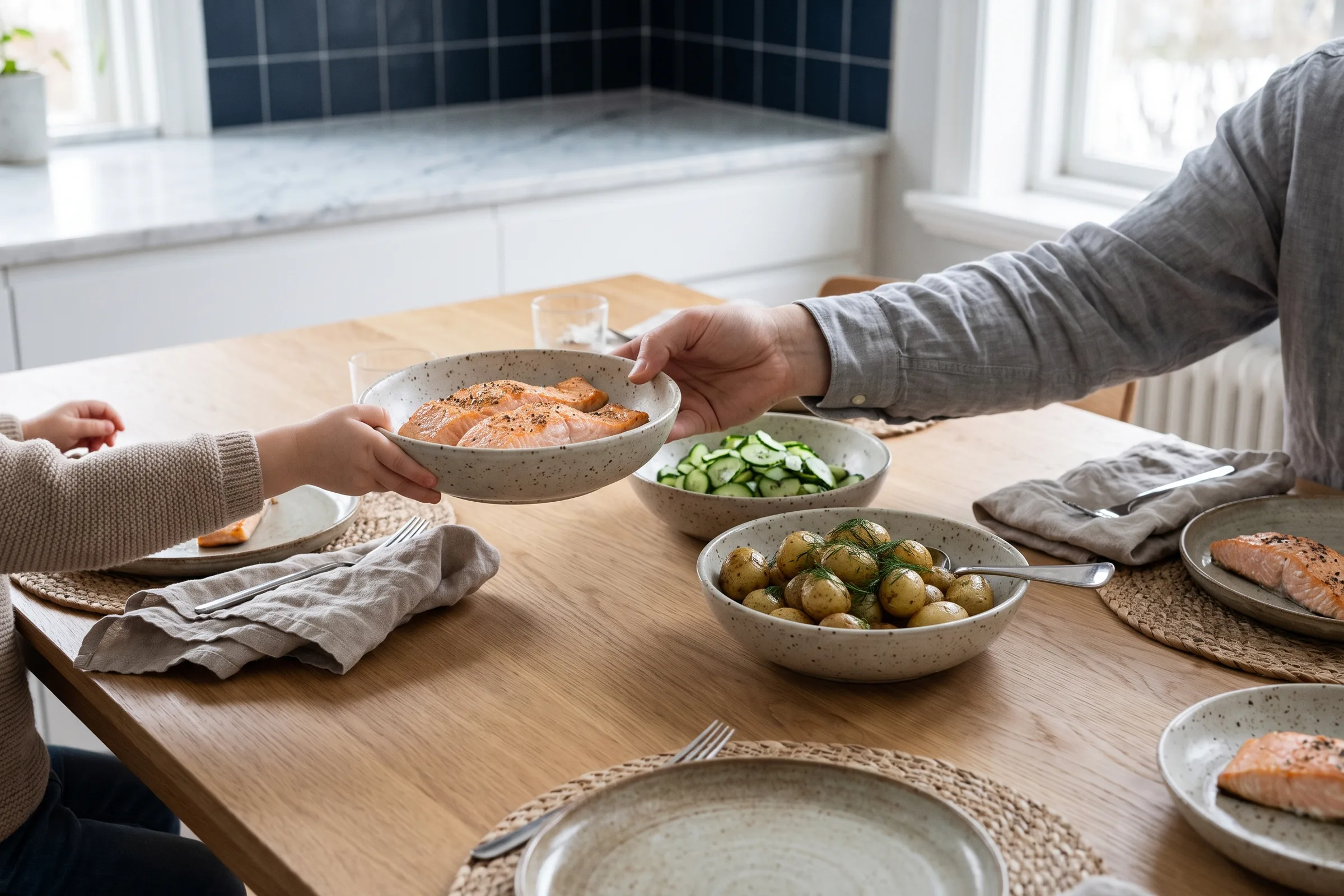 A bowl of food being passed across a dinner table